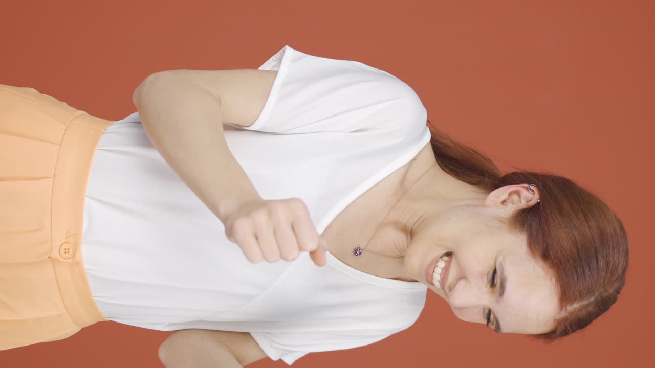 휴대폰을 바라보는 여자의 수직 비디오는 행복합니다.