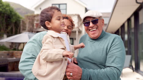 abuelo sosteniendo a su nieto con su hijo