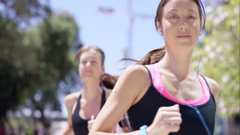 two running women fitness athletic friends jogging in the urban city