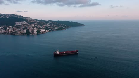 Birds-eye-view-over-beautiful-ocean-near-Mexico-beach-at-day,-ship-in-middle