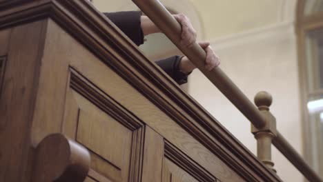 hands of defendant waiting in docks of court room
