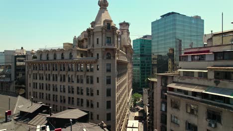 Paso-Elevado-Ascendente-En-El-Barrio-De-La-Bolsa-Con-El-Edificio-Ariztía,-El-Primer-Rascacielos-De-Santiago-De-Chile---Arquitectura-Similar-Al-Edificio-Flatiron