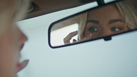 girl checking makeup car mirror close up. woman looking on red lips reflection.