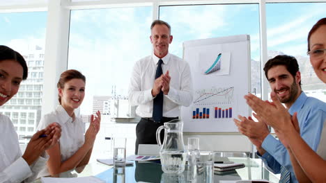 business manager applauding his staff at meeting