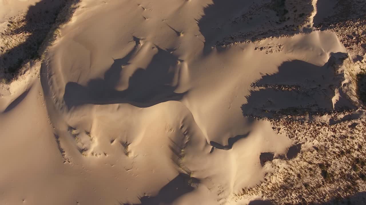 vista aérea de texturas y sombras de dunas de arena en la región árida del cabo norte, sudáfrica