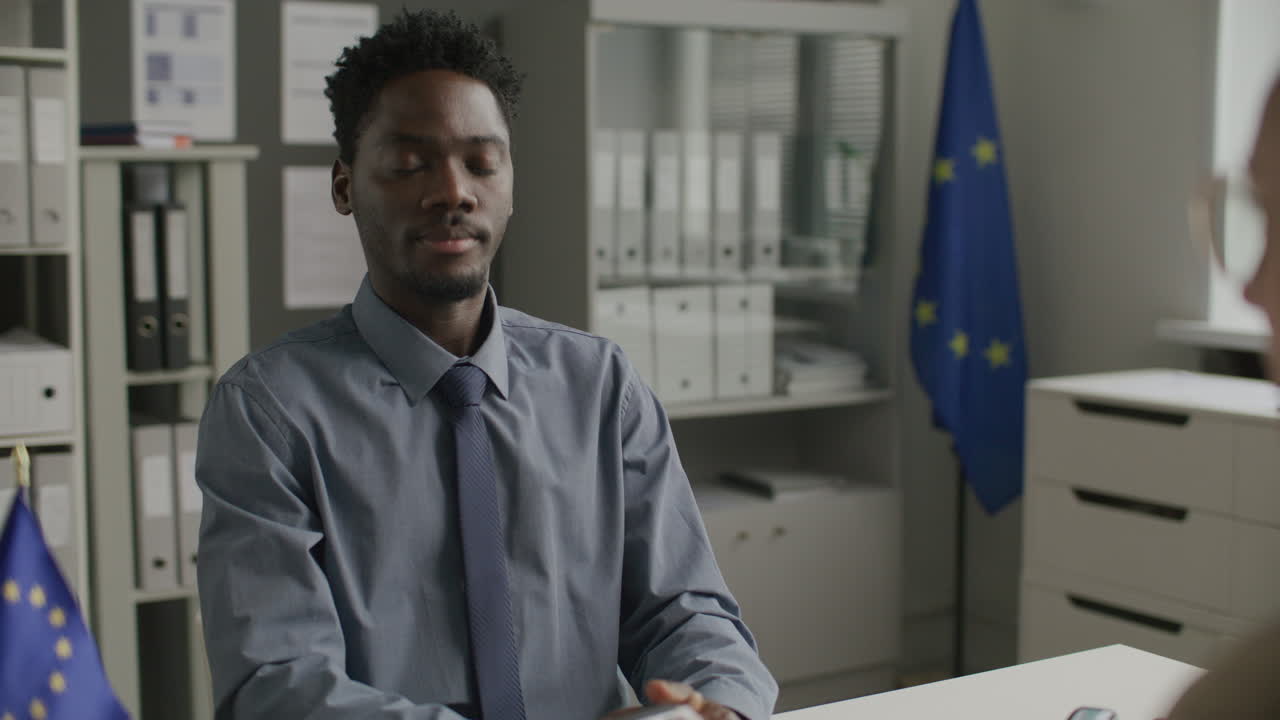 Black Man Having Visa Interview with Consular Officer at EU Embassy