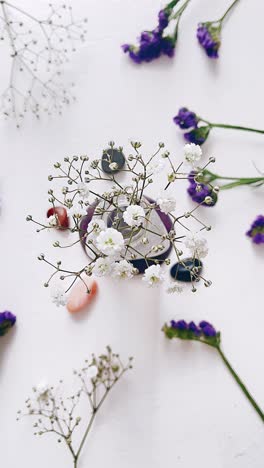 white flowers and purple flowers arrangement on a white table