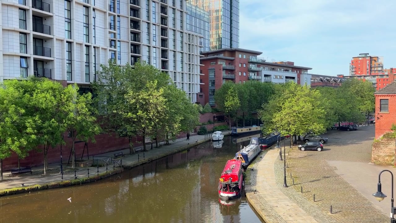 Dar tekneli Manchester Kanalı, Modern Binalar ve Su Kenarı Yürüyüş Yolu.