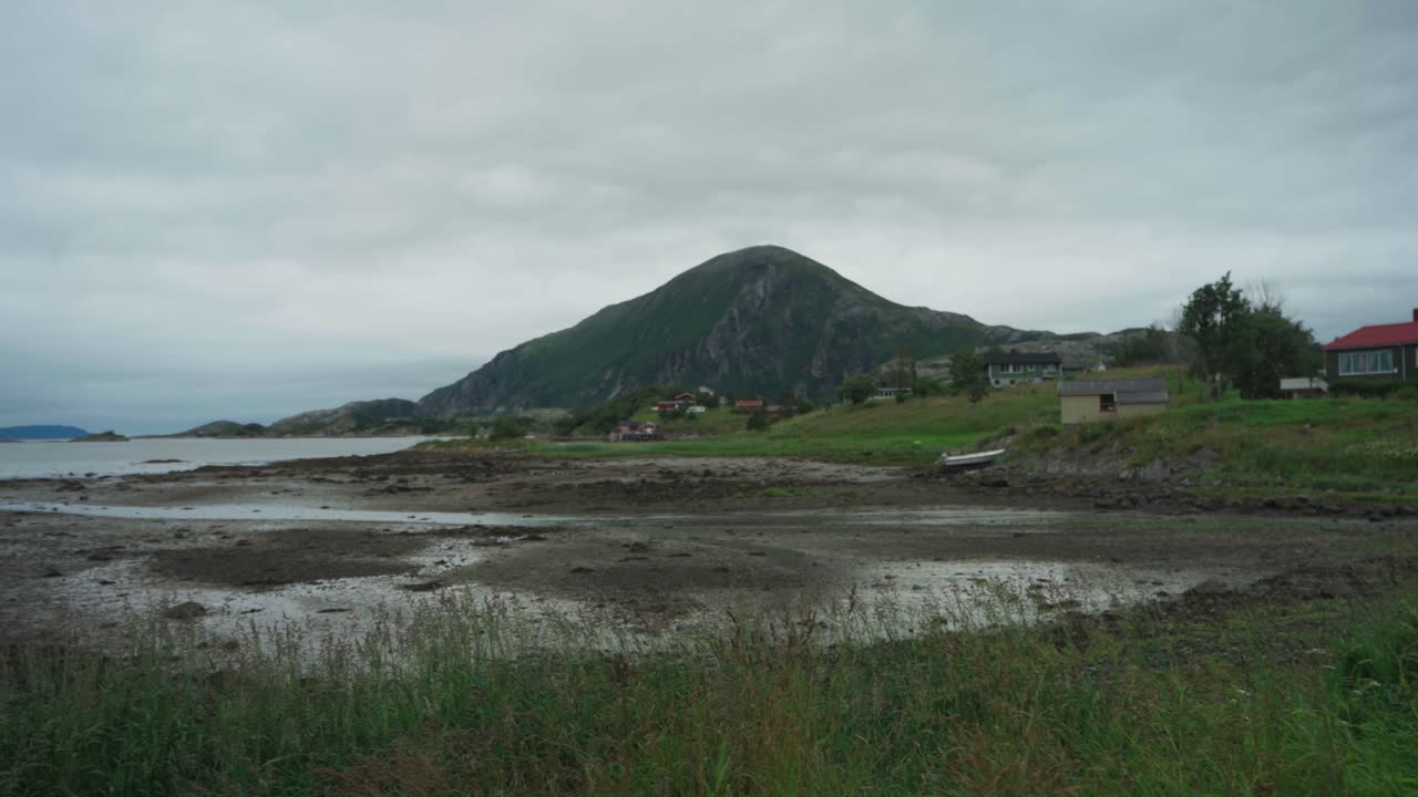 pueblo tranquilo con montañas y lago cerca de la carretera asfaltada en noruega
