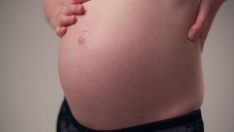 woman in eighth month of pregnancy massages belly