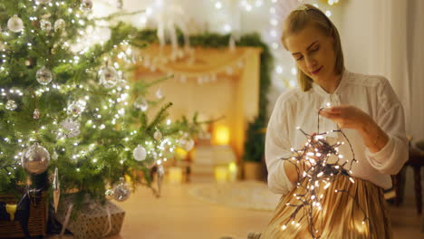 woman in cozy interior prepares christmas decorations