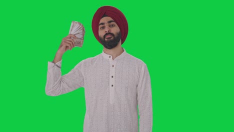 egoistic sikh indian man using money as fan green screen