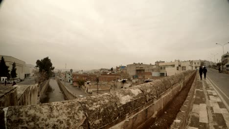 puente bajo el canal en el centro histórico de urfa dos hombres lejos de la cámara nublado día invernal urfa