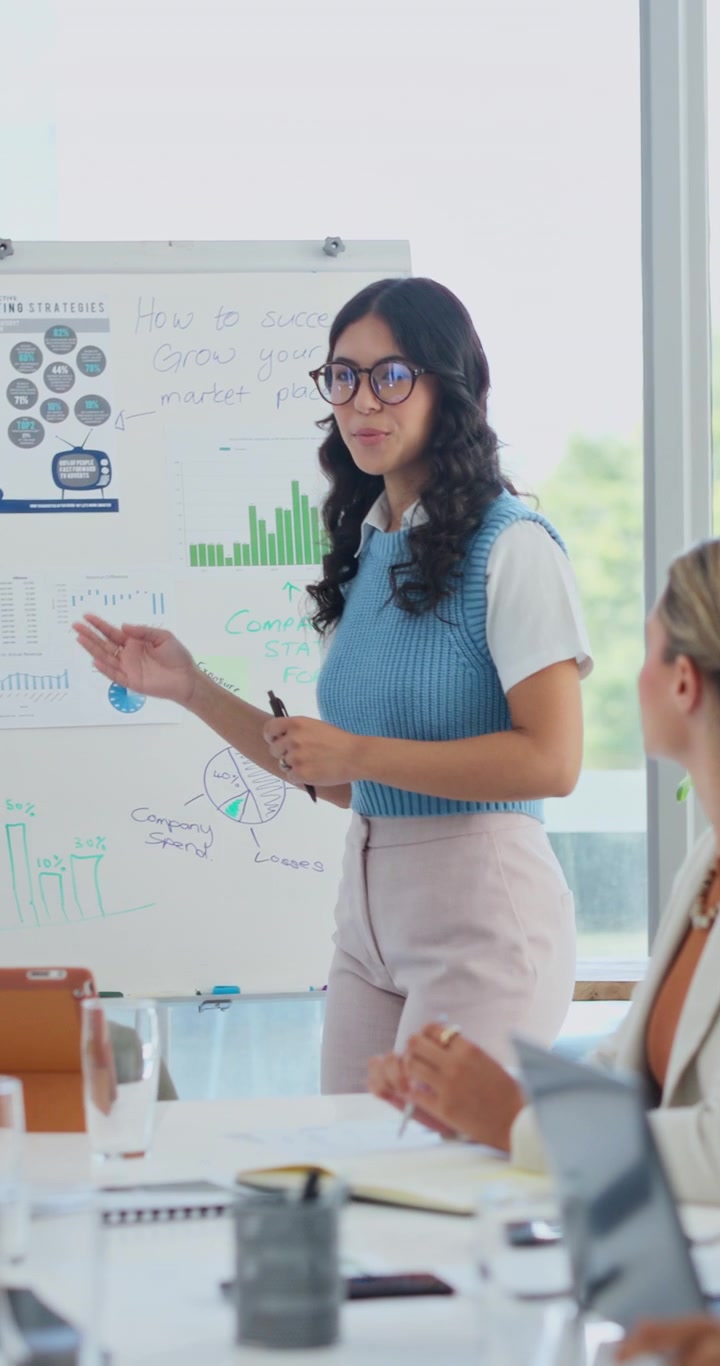 Young Businesswoman Presenting Marketing Strategies to Colleagues in Office