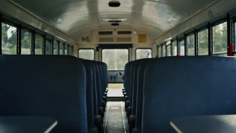 empty school bus saloon with blue seats close up. view aisle inside transport.