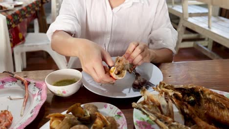 sequential prawn peeling process at dining table.