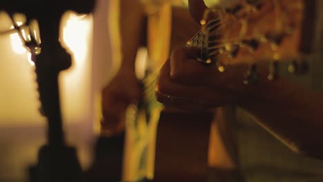 man playing acoustic guitar hand on fretboard