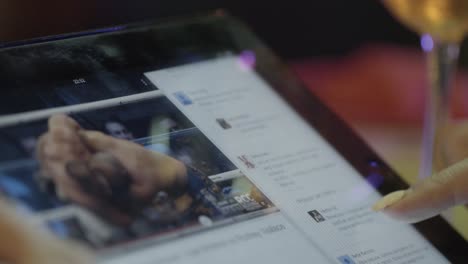 una mujer usando una tableta para ver un feed de twitter.