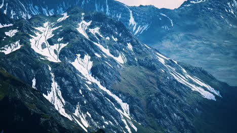 aerial over valley with snow capped mountains in distance