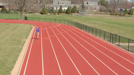 teen girl walking on a track towards camera in slow motion