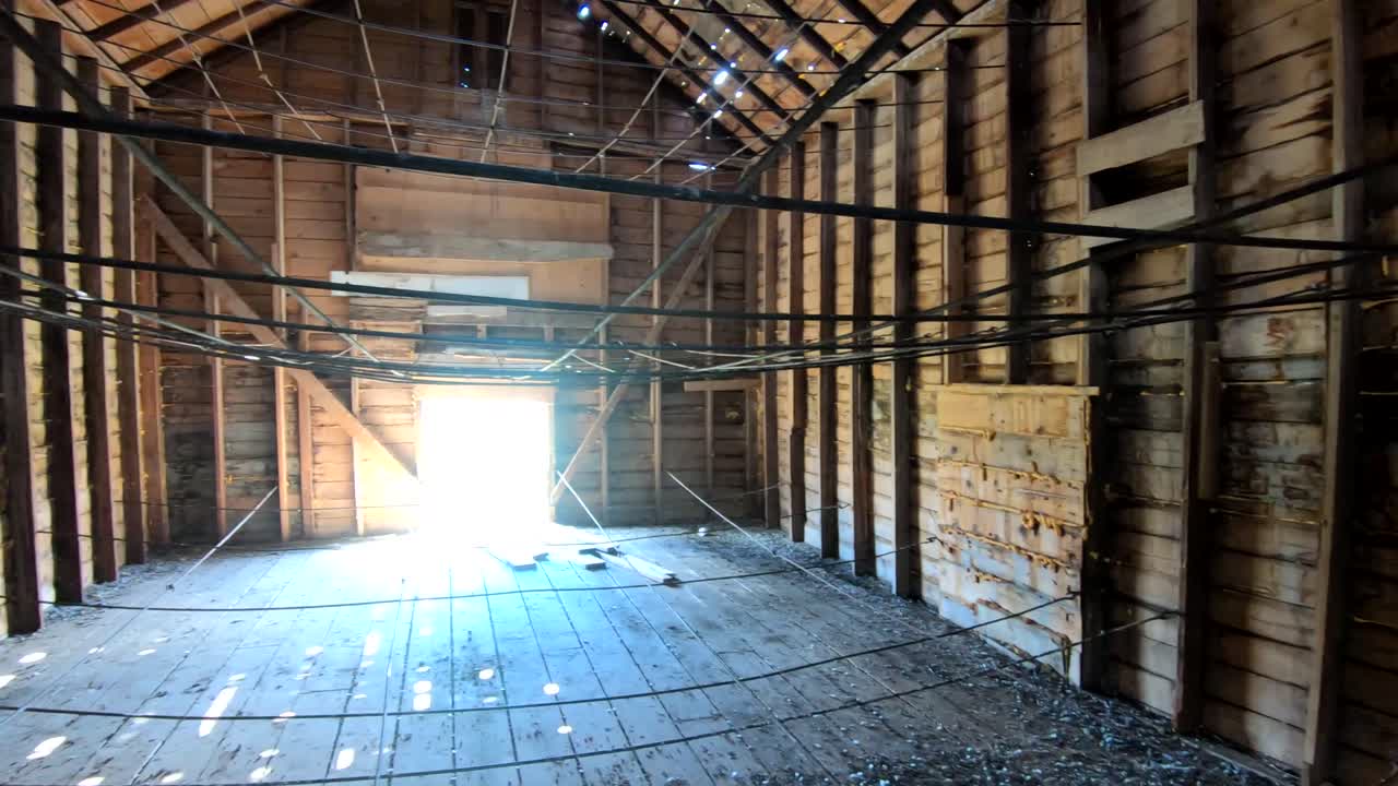 Inside on an old wooden barn in the Country on a sunny day with light coming through the windows.