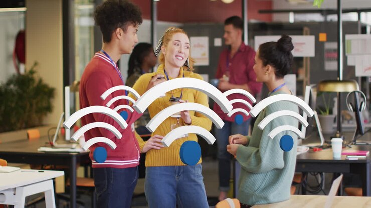 Animation af flere wi-fi-ikoner, der svæver over forskellige kolleger, der diskuterer sammen på kontoret