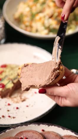 frau, die leberpaste auf toast verteilt