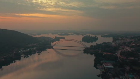 Disparo-De-Un-Dron-Moviéndose-Hacia-Arriba-Para-Ver-El-Puente-Adomi-En-El-Horizonte-En-Akosombo-Atimpoku,-Región-Oriental