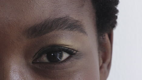 close-up-african-american-woman-eye-wearing-makeup-looking-happy-at-camera-blinking-beauty-cosmetics-white-background