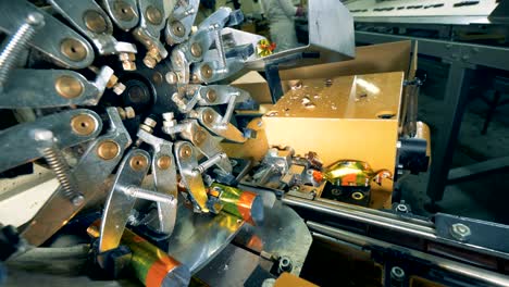 close up of a factory machine wrapping up chocolate sweets