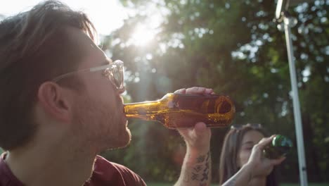 group of young friends spending time on drinking beer at the camper side.