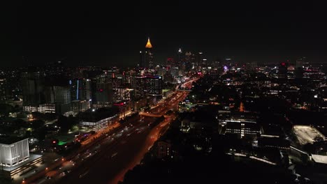 atlanta buildings downtown at night along with cars traveling down the interstate