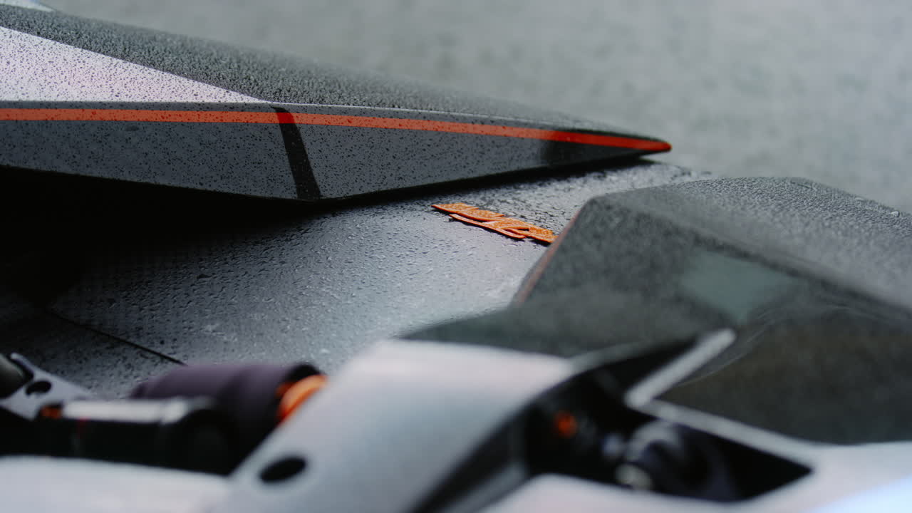 un elegante coche negro, reluciente con una nueva capa de pintura, se acercó de cerca, su superficie reluciente con gotas de lluvia de la reciente ducha