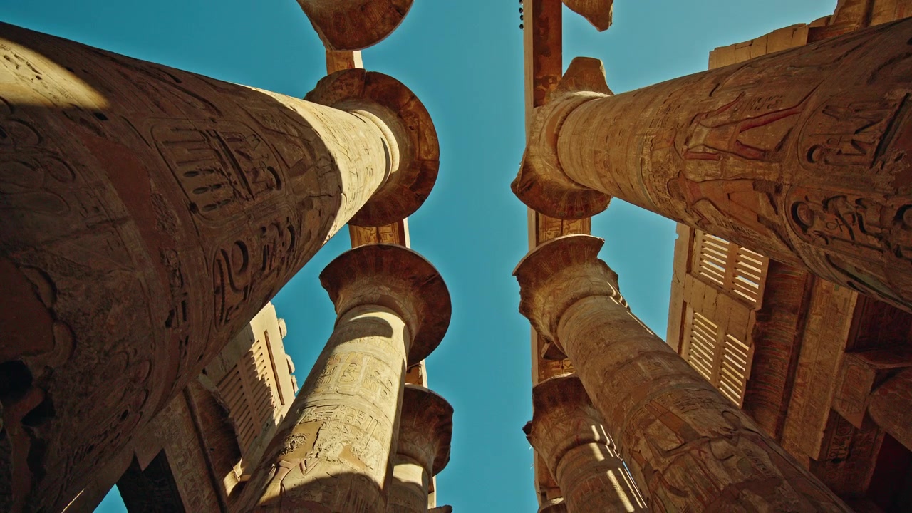 Pohled vzhůru mezi hieroglyfickými sloupy v chrámu Karnak, Luxor