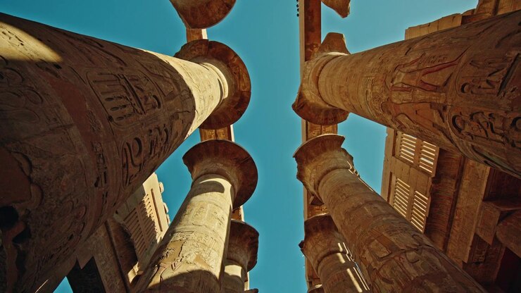Opwaarts zicht tussen hiërogliefenzuilen bij de Karnak Tempel, Luxor