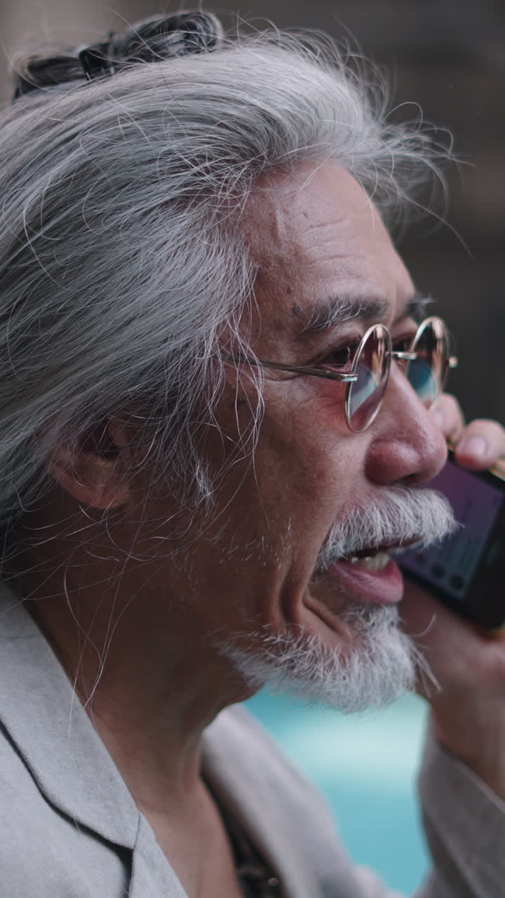 Close-up of Senior Man with Grey Hair Talking on Smartphone