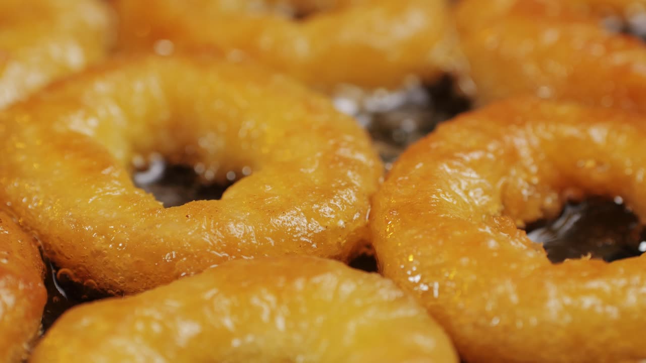 Fried crispy onion rings in a frying pan with oil close-up macro. Roasted onion rings for snacks at bar, cafe. Fast food. Delivery. Beer snacks