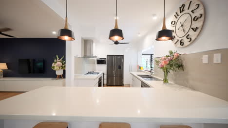 sophisticated kitchen: pine floorboards, white stone tops, stylish black pendants, bar stools, modern appliances