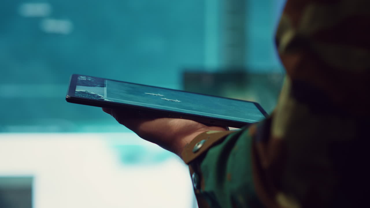 Army officer examines reconnaissance system on a world map