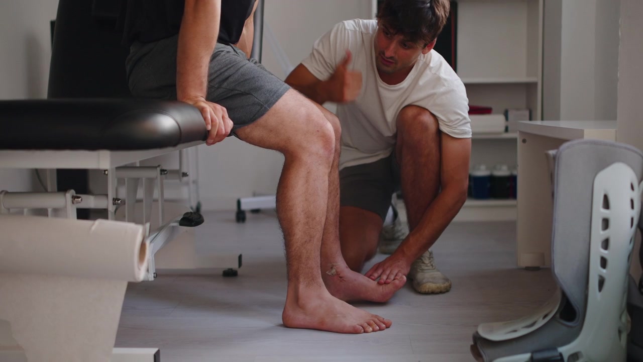 Physical Therapist Examining Patient's Injured Leg in Clinic