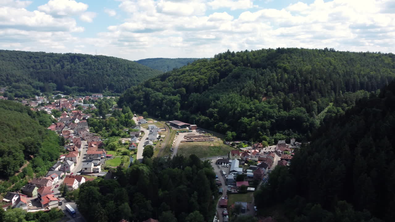 Aerial view of a village nestled in a valley surrounded by forests