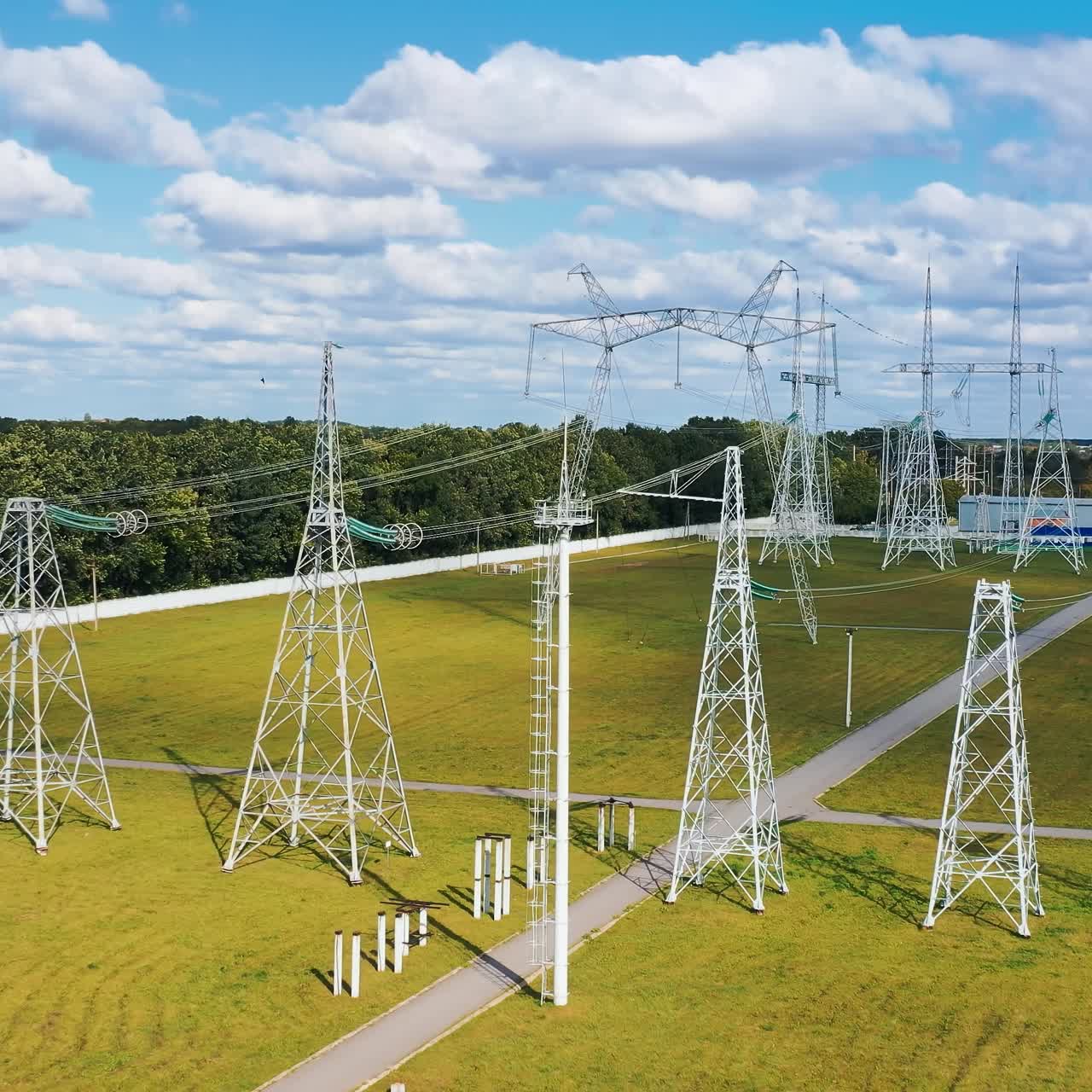 Energy distribution. Electricity pylons on field. Electricity transportation industry in summer. Energetics. Power lines with wires