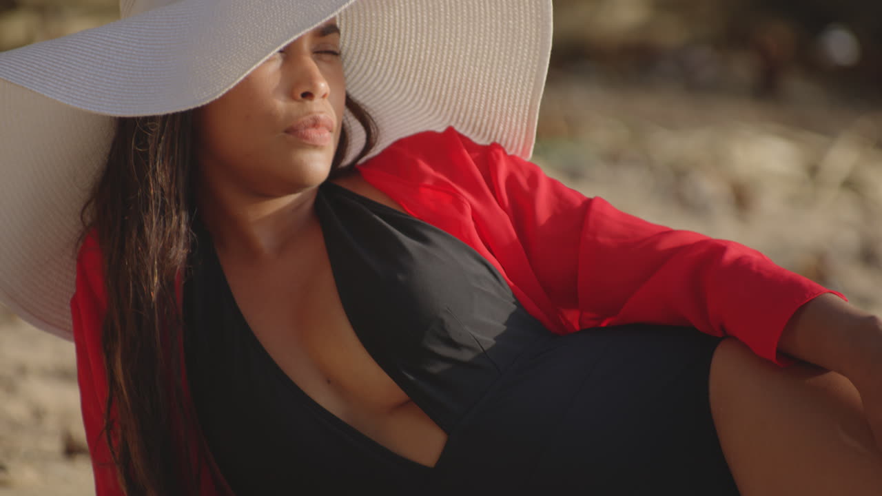 pan a lo largo de sun kissed sexy latin girls cuerpo bronceado revela feliz sonrisa tumbado en la playa, primer plano