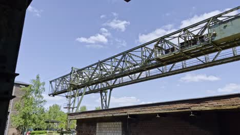 Gran-Andamio-De-Metal-Oxidado-De-Una-Grúa-En-Una-Fábrica-De-Acero-En-Alemania-Cerca-De-Viejos-Edificios-Industriales-En-El-Parque-Paisajístico-De-Duisbrug