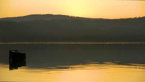 vista pacífica y tranquila de un lago durante una puesta de sol amarilla