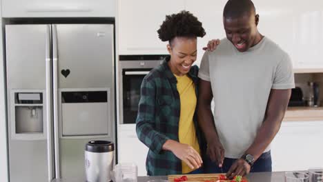 Video-Eines-Glücklichen-Afroamerikanischen-Paares,-Das-Gemeinsam-In-Der-Küche-Eine-Mahlzeit-Zubereitet