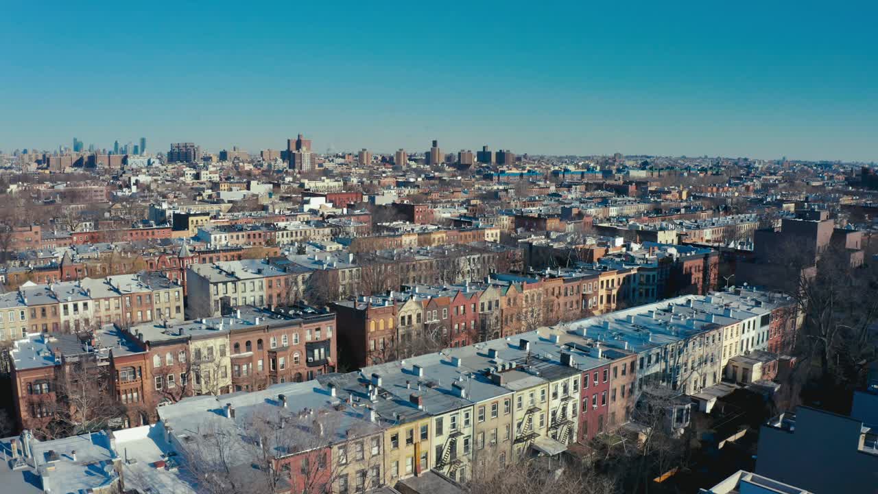 increíble toma aérea de drones de filas de apartamentos y edificios de viviendas de brooklyn, nueva york, con el horizonte de manhattan y la ciudad de nueva york en el fondo.