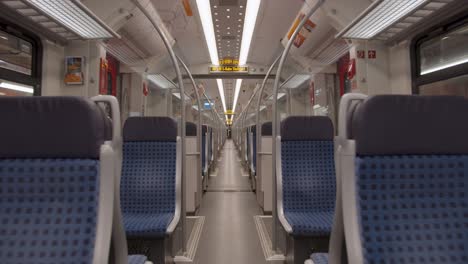 empty deutsche bahn train interior, symmetrical view down the center aisle, blue seats, destination stuttgart