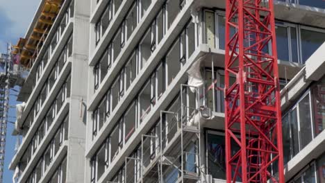 Toma-En-Cámara-Lenta-De-Un-Edificio-De-Hormigón-En-Obras-Con-Una-Grúa