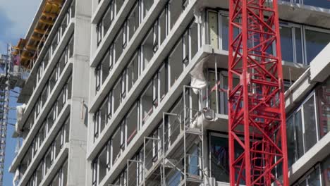 toma en cámara lenta de un edificio de hormigón en obras con una grúa